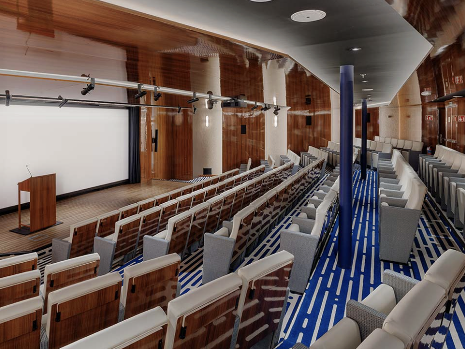 Atlas auditorium with a presentation screen, lectern and tiered seating